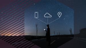 Person with phone standing in the road in a hexagon with icons of phone, cloud, and a pinpoint above their head