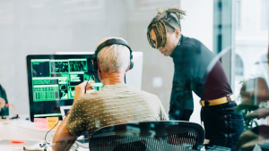 Colleagues gather to discuss technology issues around a computer screen