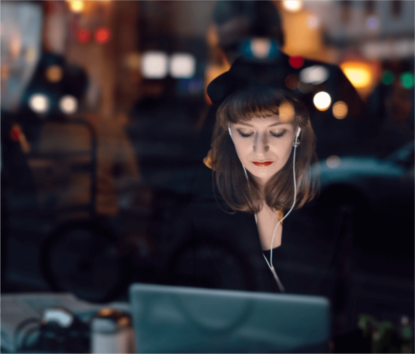 Individual working in front of their laptop in a public setting